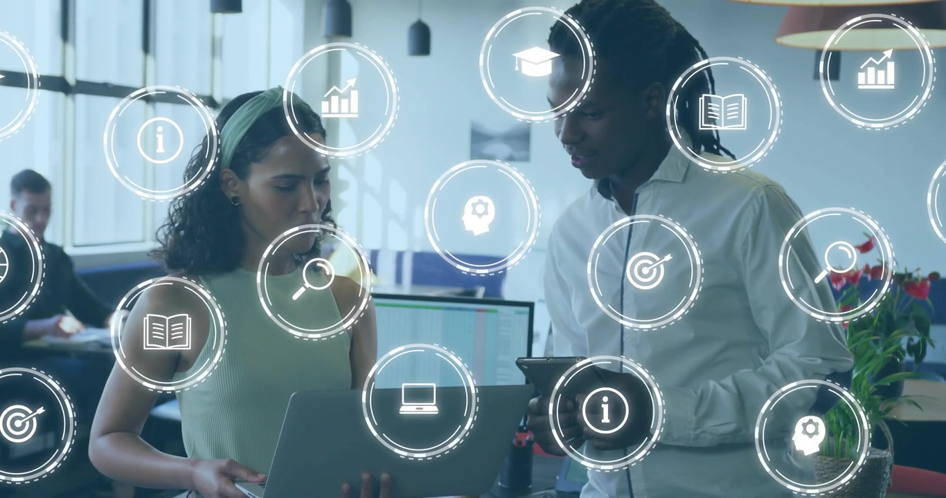 After pausing, two colleagues holding laptop and tablet analyzing business data with floating icons