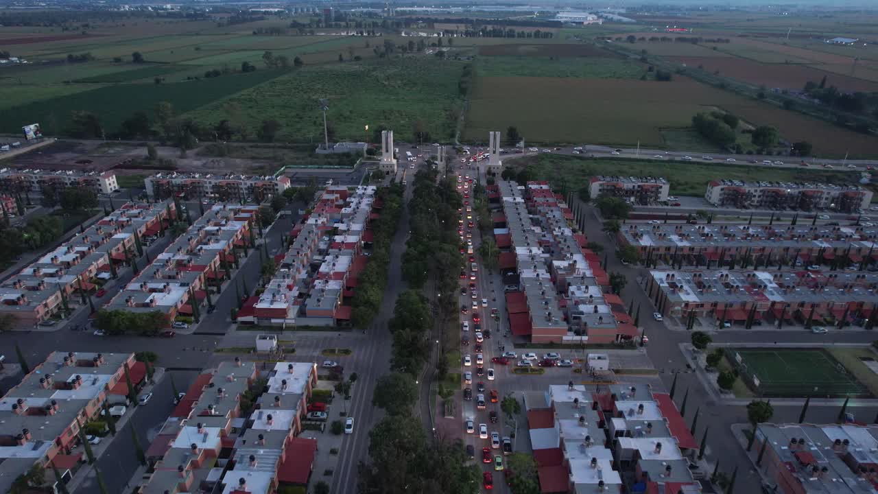 una larga fila de autos a la salida de un barrio de arboledas