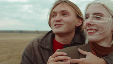 pareja alegre abrazándose en el campo de otoño