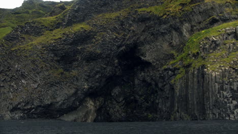 Person-walking-to-Halsanefshellir-Cave-on-Reynisfjara-Black-Beach-in-Iceland