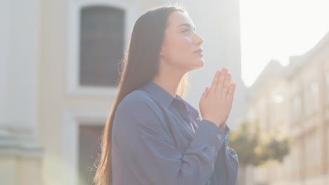 retrato de una mujer orando con los ojos cerrados a dios pidiendo bendición ayuda perdón al aire libre