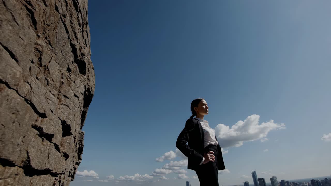 Businesswoman on a mountaintop overlooking the city