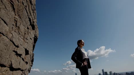 businesswoman on a mountaintop overlooking the city