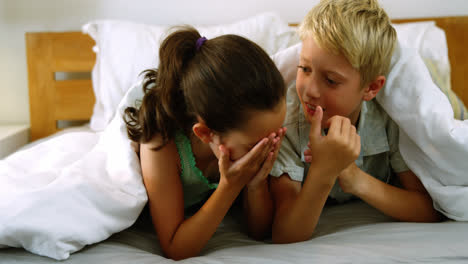 hermanos interactuando entre sí en la cama en el dormitorio