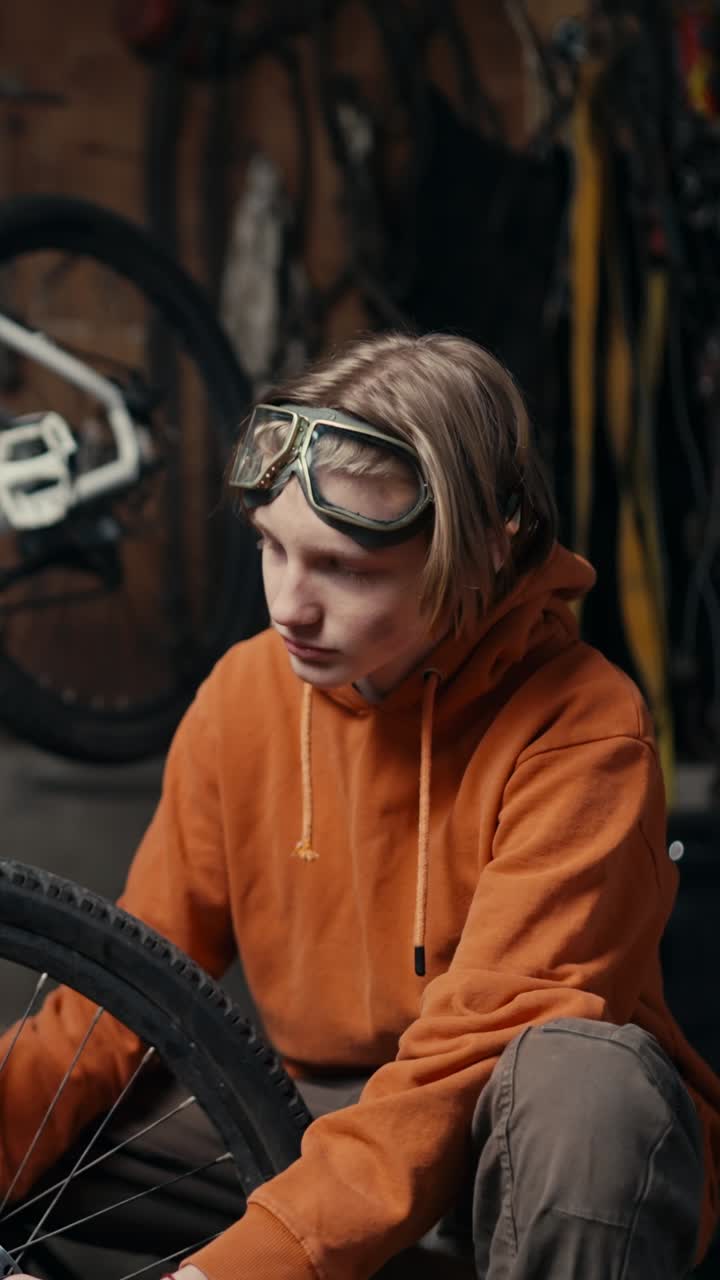 Teenager repairing a bicycle in a garage