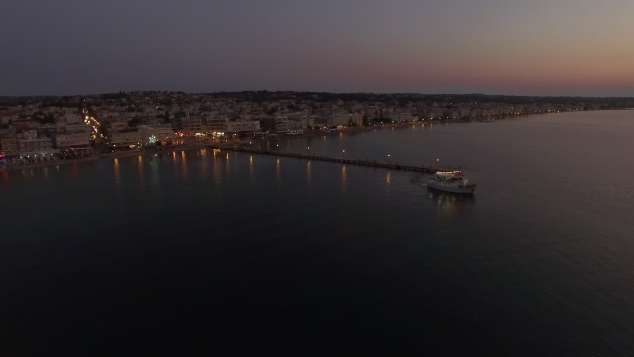 volando sobre un barco turístico en el mar por la noche