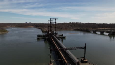 An-aerial-view-of-a-train-crossing-the-Pelham-Bay-Railroad-Bridge-in-The-Bronx,-New-York-on-a-sunny-morning