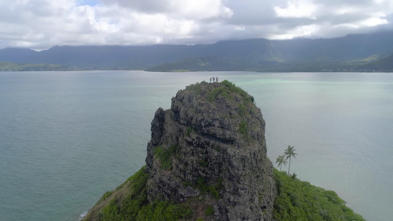 생동감 넘치는 색상과 푸른 흐린 하늘을 가진 오아후 하와이의 차이나맨스 모자 모콜리 위에 서 있는 모험가들