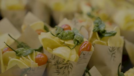 Cerca-De-Bolsas-De-Papas-Fritas-Adornadas-Con-Tomate-Y-Pimiento-Verde-Picante-En-El-Puesto-De-Comida-Del-Mercado-Público