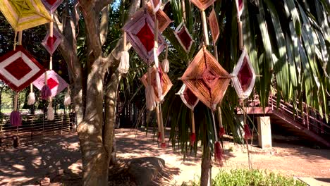 decorative mobiles hanging from trees in sunlight