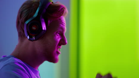 excited player celebrating cyber success closeup. joyful man shouting in neon