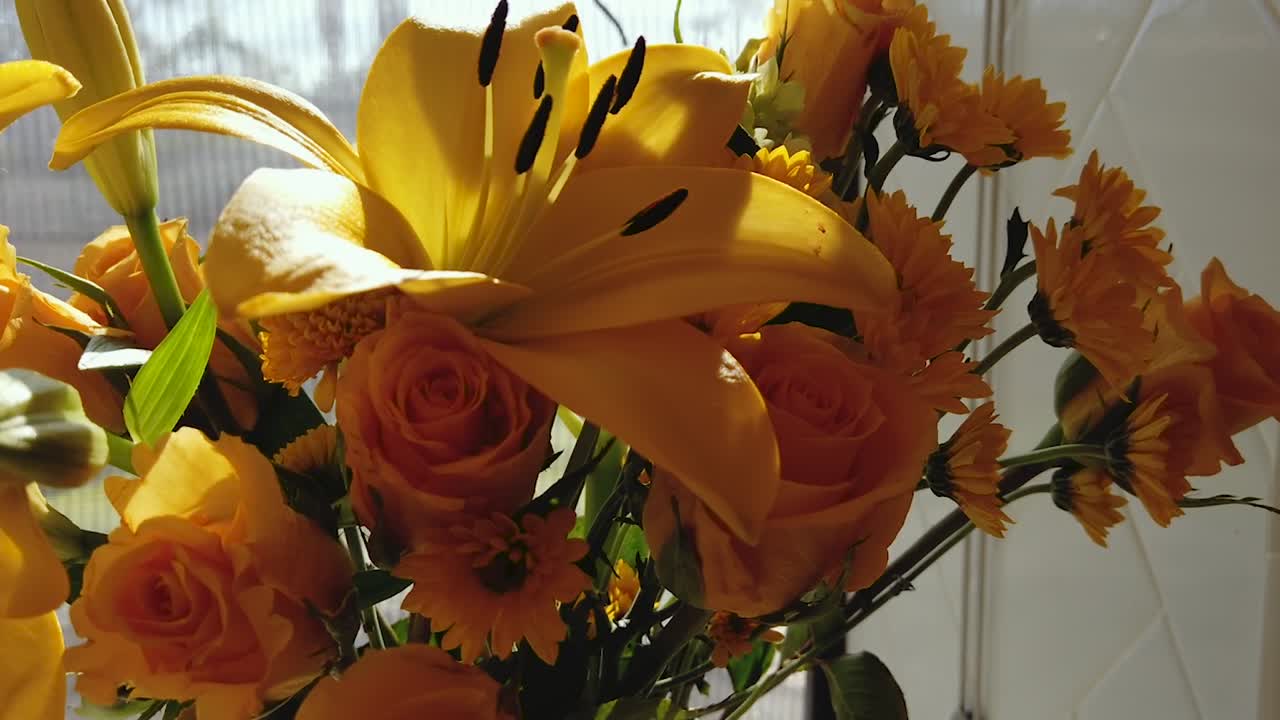 Timelapse of a bouquet of yellow flowers reacting to the sunlight passing through a window.