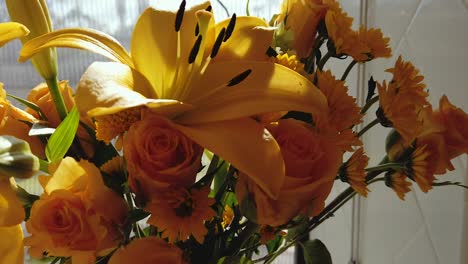 timelapse of a bouquet of yellow flowers reacting to the sunlight passing through a window.