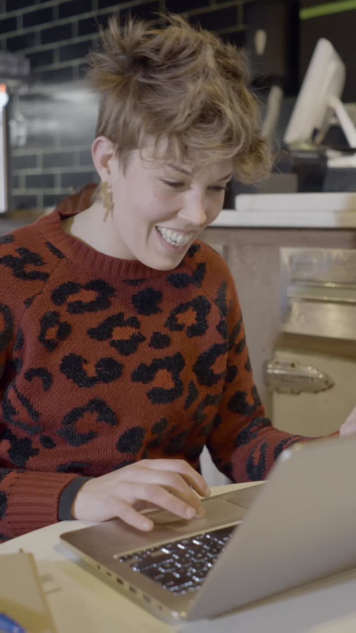 Smiling person working on a laptop
