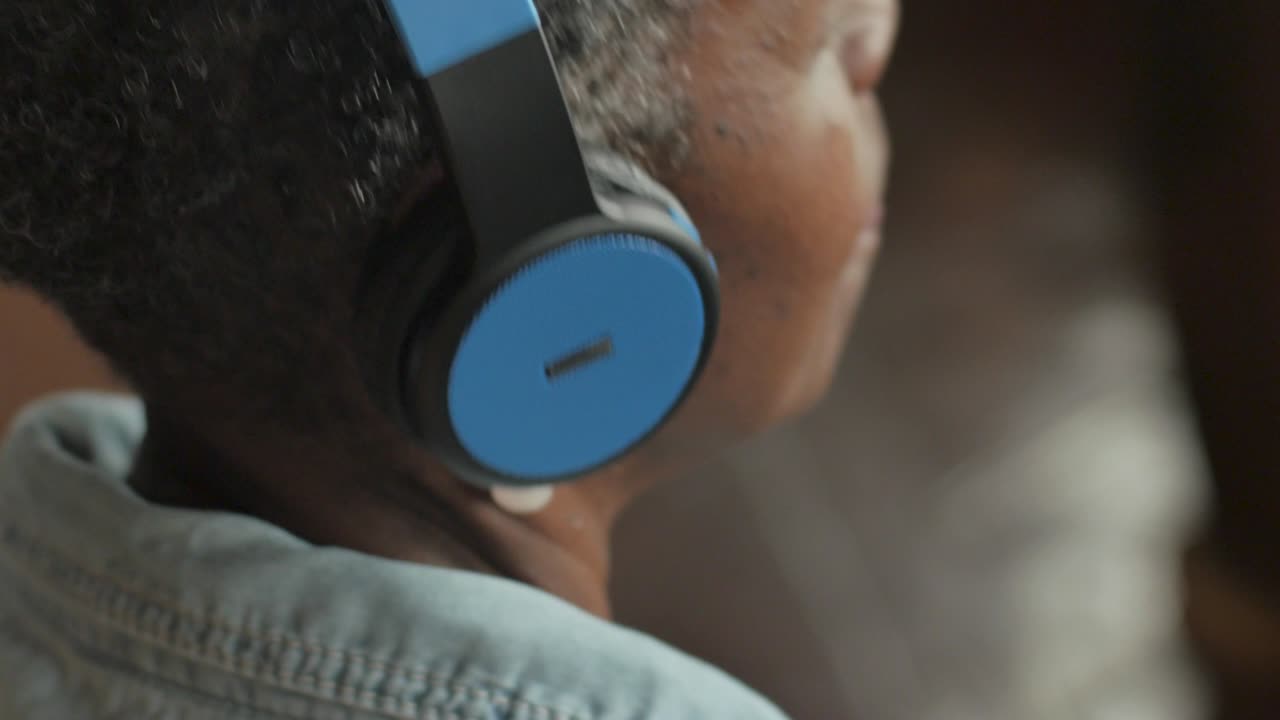 Senior African-American woman putting on wireless headphones