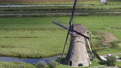 drone fly by iconic rural dutch windmill zooming in on black metal blades