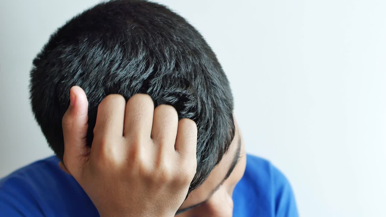 머리를 고 있는 젊은 남자