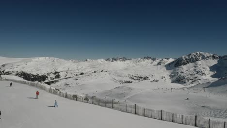 Familias-Con-Niños-Esquiando-Con-Una-Hermosa-Vista-Aérea-De-La-Montaña-Cubierta-De-Nieve-En-Un-Día-Soleado