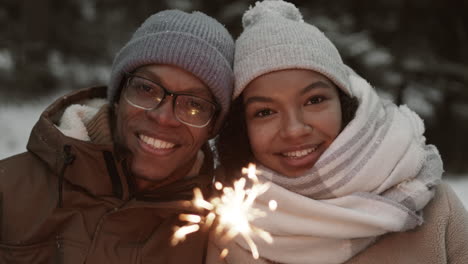 happy couple celebrating winter day with sparkler