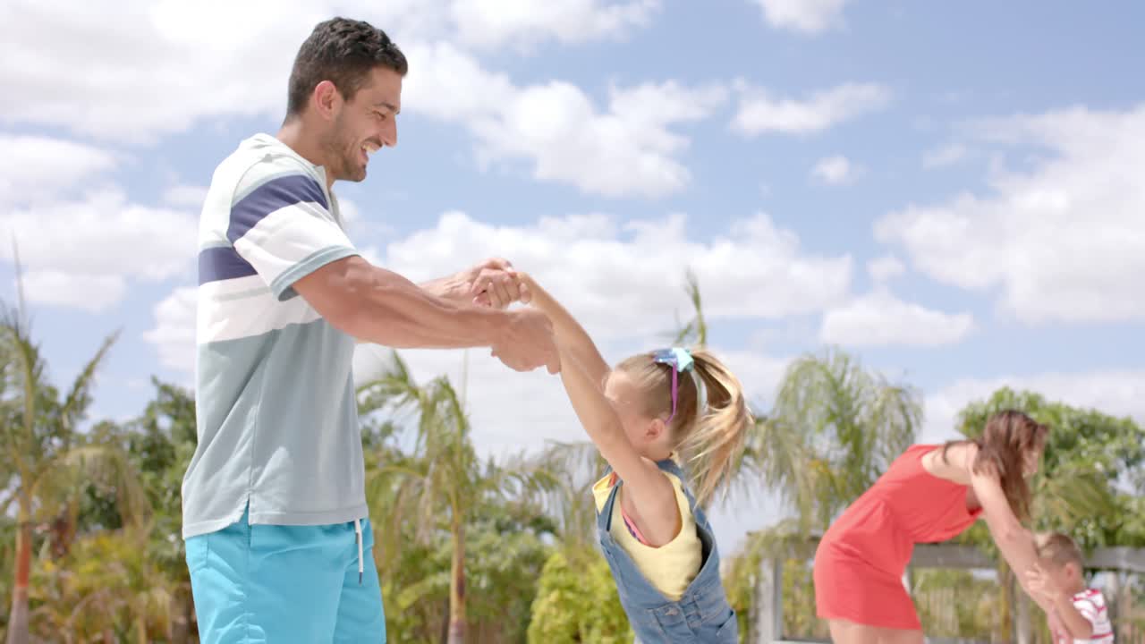 해변 집의 수영장에서 놀고 있는 행복한 백인 가족