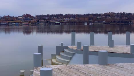 a large wooden dock patio overlooking the hudson river and toward the city of newburgh, new york, as seen from beacon, new york