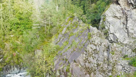 Aerial-Past-Rock-Face-Revealing-Winding-Road-In-Eisenkappel-Vellach,-Austria