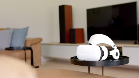 a virtual reality headset rests on a table in a modern living room