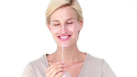 una mujer rubia bebiendo jugo de verduras.