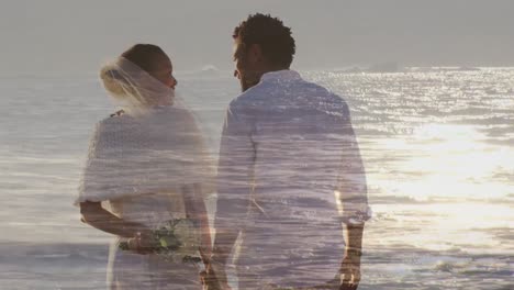 animation of happy newly married african american couple over seascape