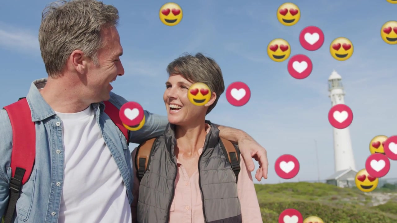 Mature couple posing sea lookout man hugging woman causing hearts rising over them for social media