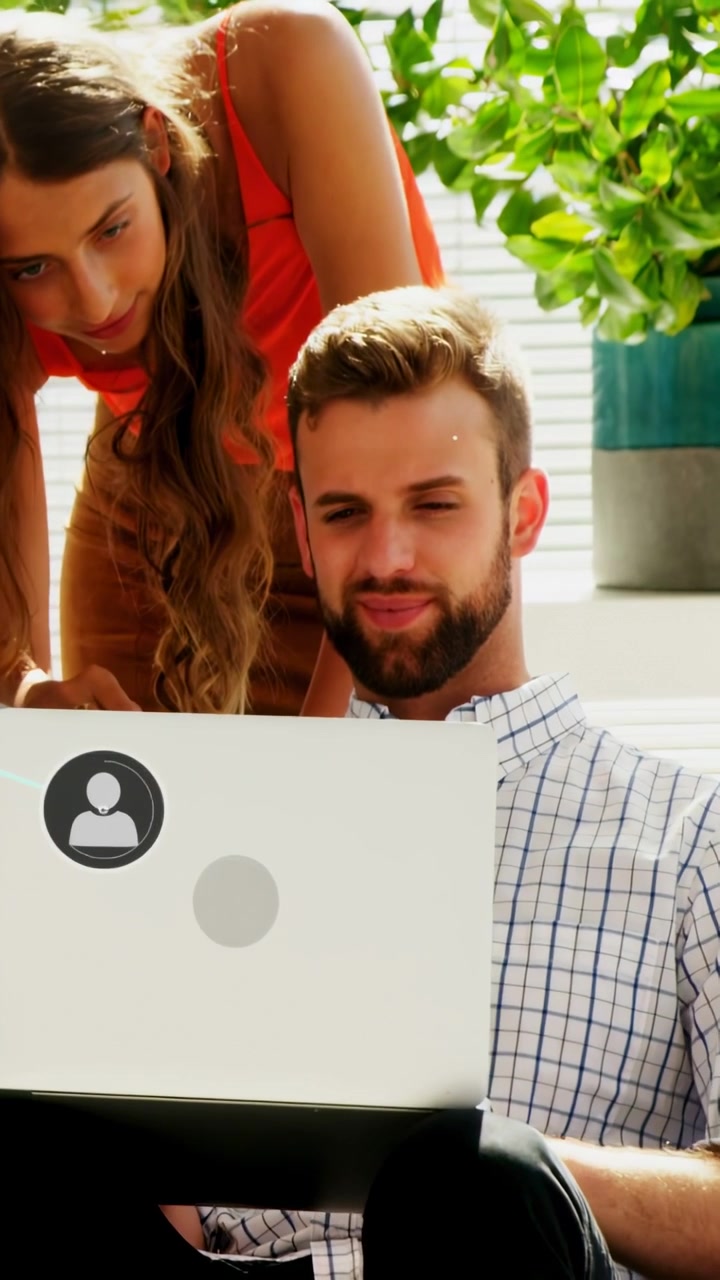 Video vertical: Mujer señalando una laptop, activando iconos de usuario en la pantalla, hombre sonriendo compartiendo para el equipo.