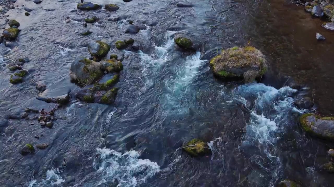 L'acqua limpida del fiume scorre impetuosa tra rocce e massi in un pittoresco ruscello di montagna giapponese, creando correnti naturali, increspature e piccole aree di acqua bianca