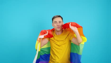 Man celebrating with LGBT rainbow flag on blue background
