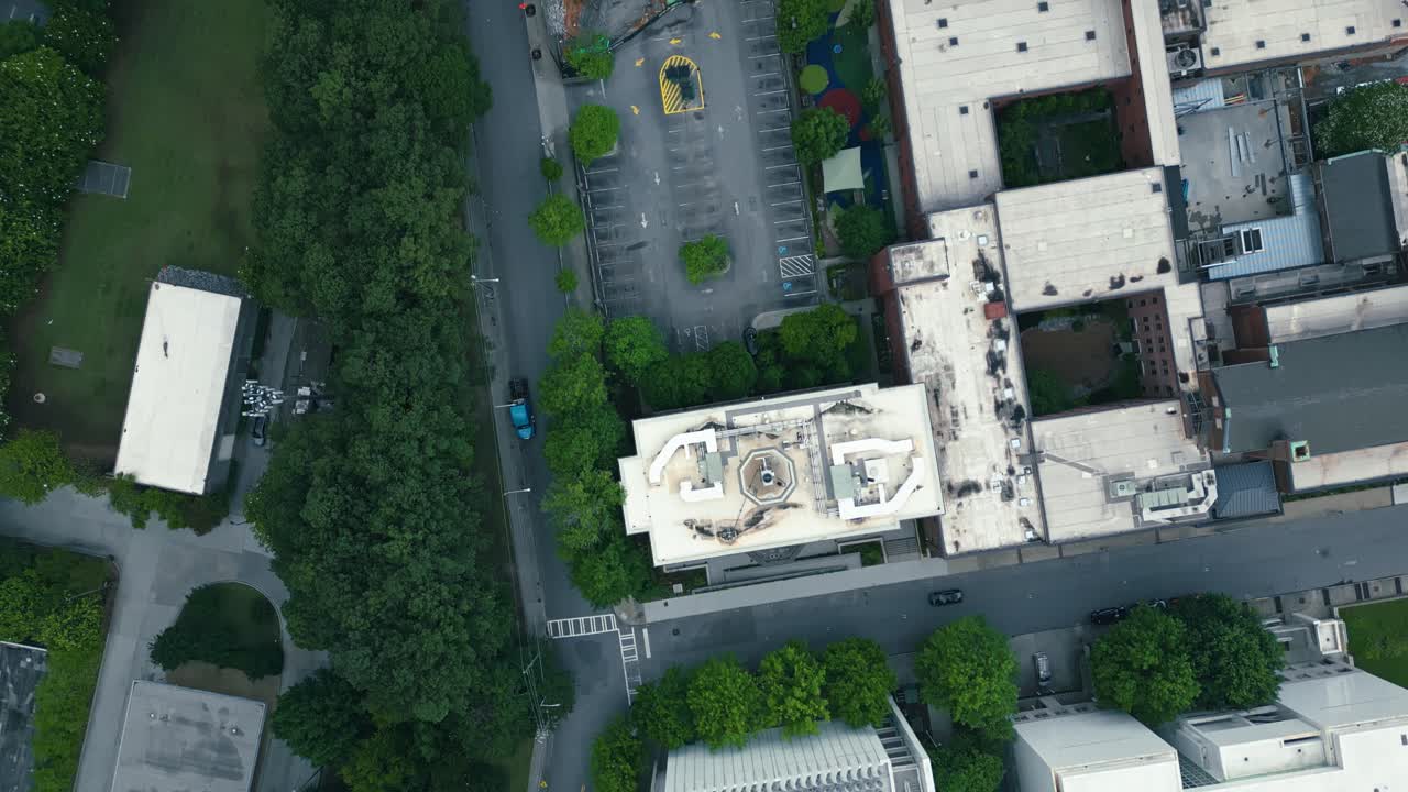 Aerial top down shot of rooftops of high-rise buildings and roof swimming pool of hotel in Atlanta, Georgia. Traffic on street in downtown. Luxury skyscrapers of american town.