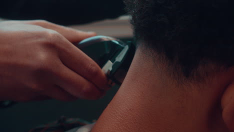 Una-Increíble-Toma-En-Cámara-Lenta-De-Un-Corte-De-Pelo-De-Un-Peluquero-Profesional-En-Una-Barbería-Con-Un-Afeitado-Para-Un-Joven-Afro-Durante-La-Tarde-En-4k