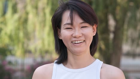 happy woman with black hair in city park during daytime