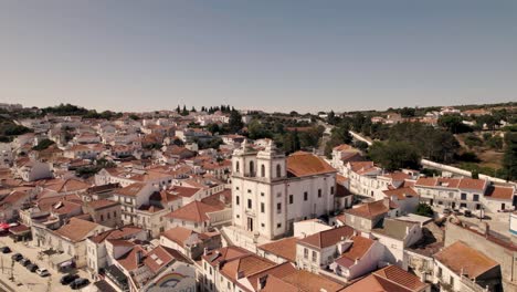 iglesia histórica con dos torres y majestuoso paisaje urbano de la ciudad de alcacer do sal en portugal, vista aérea de drones
