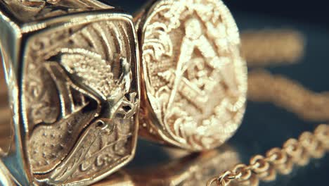close-up of ornate gold ring with bird design and gold chain