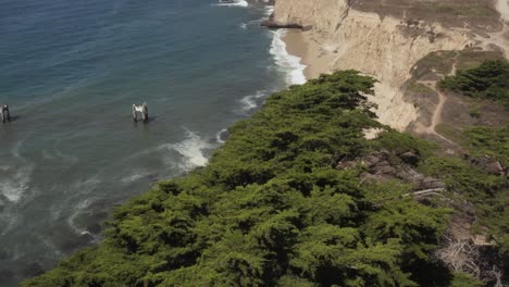 aerial view of old broken pier made of cement in the middle of the ocean near santa cruz california