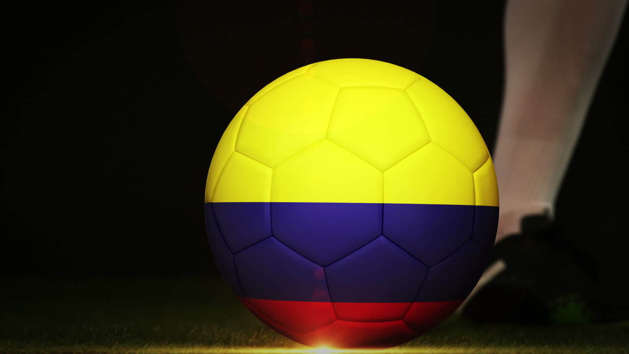 jugador de fútbol pateando la pelota de la bandera de colombia