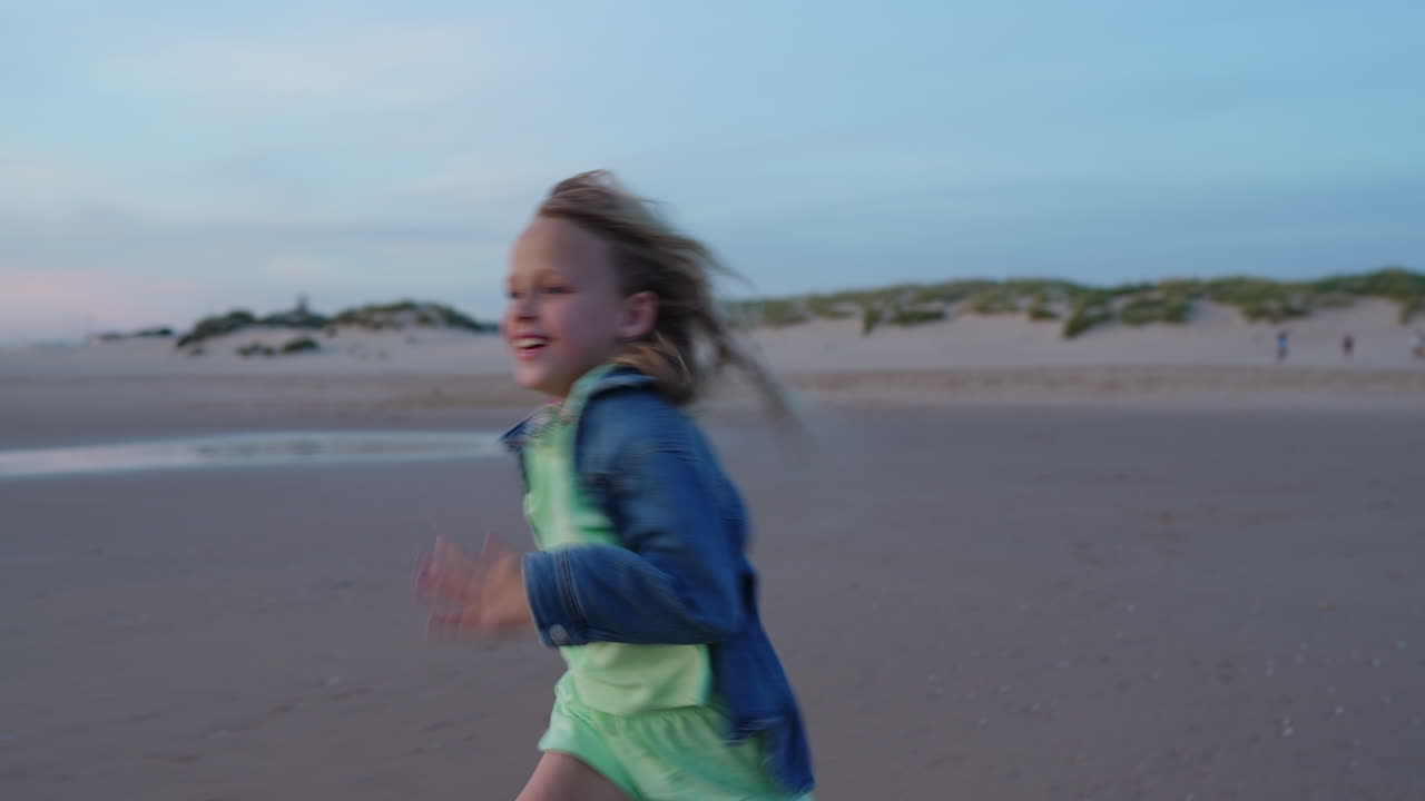 Young girl running on the beach at sunset