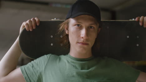 kaukasischer skateboarder in einem zerstörten gebäude.