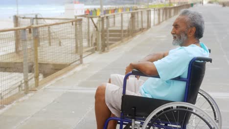 side view of thoughtful disabled active senior african american man in wheelchair on promenade 4k