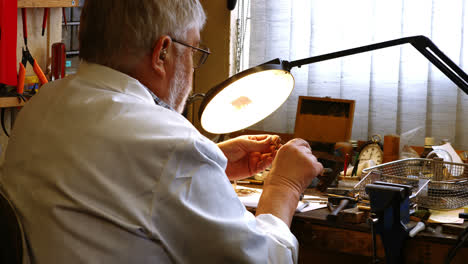 rear view of horologist repairing a watch