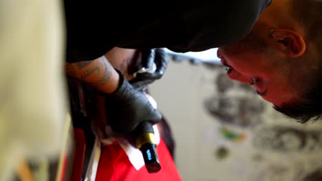 tattoo artist at work: close-up of tattooing process