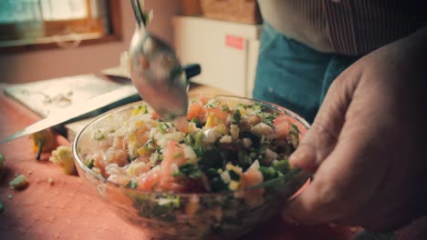 chef mezclando todas las verduras con una cuchara en un bol