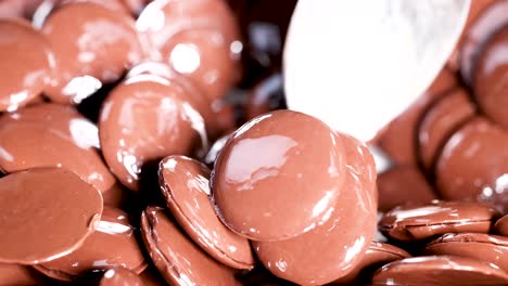 spoon stirring glossy chocolate discs together