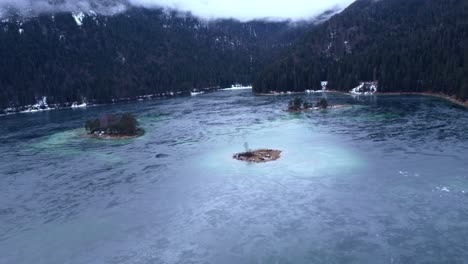 阿爾卑斯山下一個令人驚訝的凍結湖的空中景色, 島<unk>和山脈都被雪覆蓋