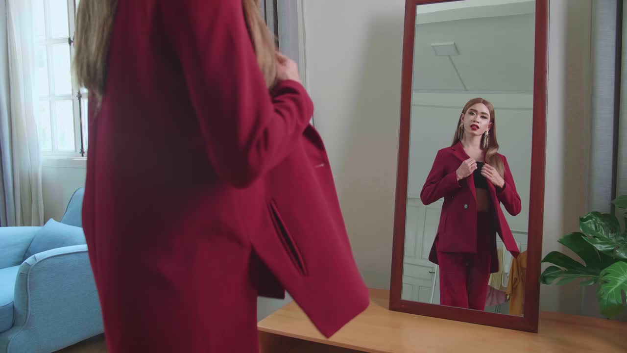 Asian Transgender Woman Standing In Front Of Mirror Wearing A Red Cloth