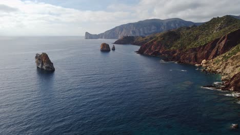 Epic-aerial-shot-of-Masua-rugged-coastline-with-sea-stacks,-South-Sardinia